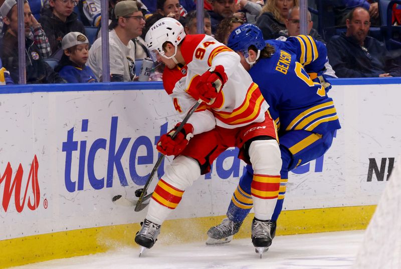 Nov 9, 2024; Buffalo, New York, USA;  Calgary Flames defenseman Brayden Pachal (94) and Buffalo Sabres left wing Zach Benson (9) go after a loose puck during the second period at KeyBank Center. Mandatory Credit: Timothy T. Ludwig-Imagn Images