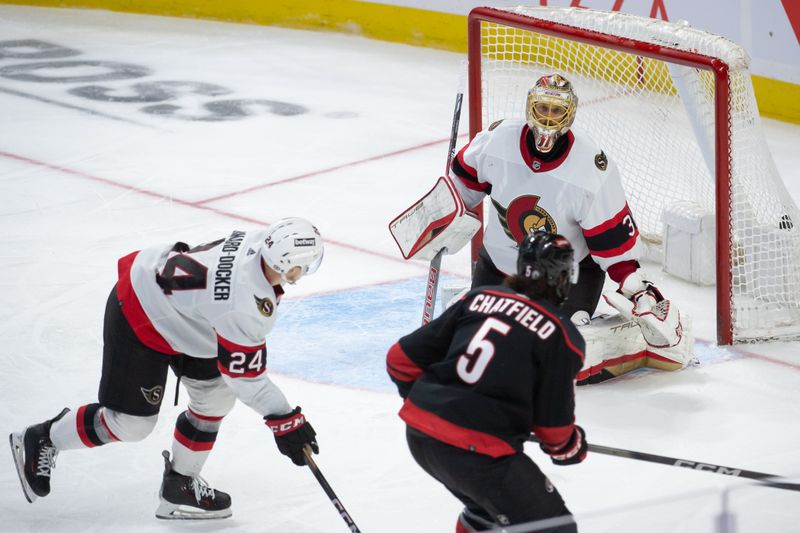 Mar 17, 2024; Ottawa, Ontario, CAN; Carolina Hurricanes defenseman Jalen Chaffield (5) scores against Ottawa Senators goalie Anton Foersberg (31) in the third period at the Canadian Tire Centre. Mandatory Credit: Marc DesRosiers-USA TODAY Sports