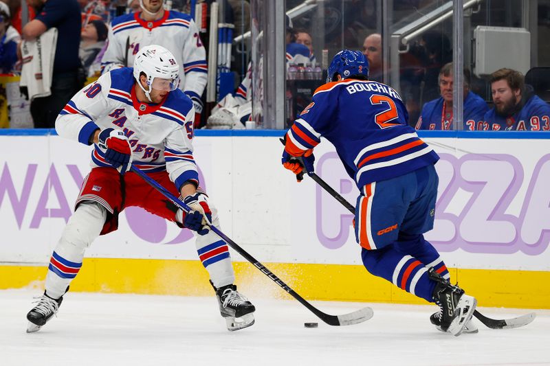 Nov 23, 2024; Edmonton, Alberta, CAN; New York Rangers forward Will Cuylle (50) tries to move the puck past Edmonton Oilers defensemen Evan Bouchard (2) during the second period at Rogers Place. Mandatory Credit: Perry Nelson-Imagn Images