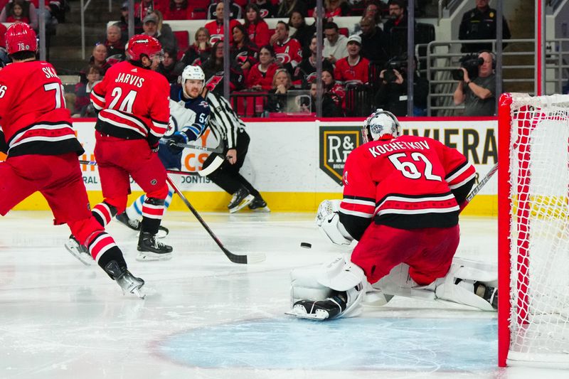 Mar 2, 2024; Raleigh, North Carolina, USA; Winnipeg Jets defenseman Dylan Samberg (54) takes a shot at Carolina Hurricanes goaltender Pyotr Kochetkov (52) during the second period at PNC Arena. Mandatory Credit: James Guillory-USA TODAY Sports