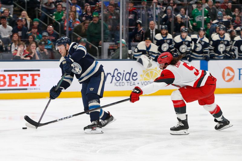 Mar 17, 2026; Columbus, Ohio, USA; Columbus Blue Jackets center Mathieu Olivier (24) wrists a shot on goal as Carolina Hurricanes defenseman Jalen Chatfield (5) defends during the second period at Nationwide Arena. Mandatory Credit: Russell LaBounty-Imagn Images