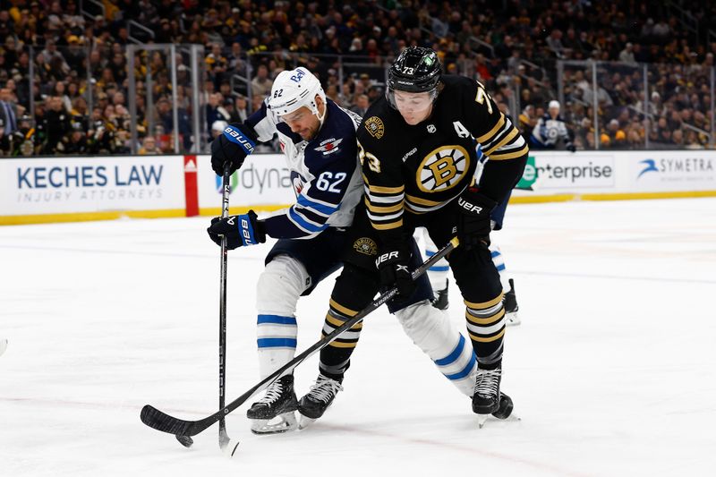 Jan 22, 2024; Boston, Massachusetts, USA; Boston Bruins defenseman Charlie McAvoy (73) and Winnipeg Jets right wing Nino Niederreiter (62) battle for a loose puck during the first period at TD Garden. Mandatory Credit: Winslow Townson-USA TODAY Sports