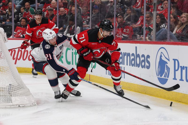 Dec 1, 2025; Newark, New Jersey, USA; New Jersey Devils defenseman Jonas Siegenthaler (71) and Columbus Blue Jackets center Isac Lundeström (21) battle for the puck during the first period at Prudential Center. Mandatory Credit: Ed Mulholland-Imagn Images