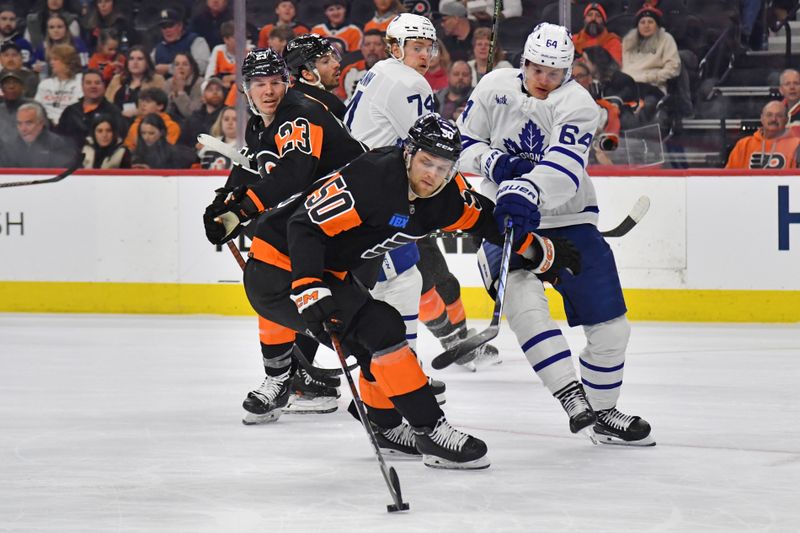 Mar 19, 2024; Philadelphia, Pennsylvania, USA; Philadelphia Flyers defenseman Adam Ginning (50) keeps puck away from Toronto Maple Leafs center David Kampf (64) during the second period at Wells Fargo Center. Mandatory Credit: Eric Hartline-USA TODAY Sports