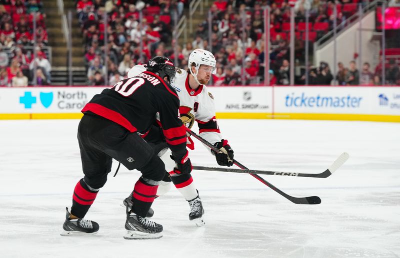 Nov 16, 2024; Raleigh, North Carolina, USA;  Ottawa Senators defenseman Thomas Chabot (72) gets the shot past Carolina Hurricanes left wing Eric Robinson (50) during the second period at Lenovo Center. Mandatory Credit: James Guillory-Imagn Images