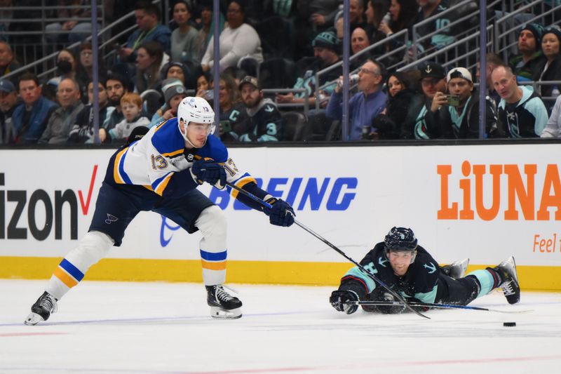 Jan 26, 2024; Seattle, Washington, USA; St. Louis Blues right wing Alexey Toropchenko (13) and Seattle Kraken defenseman Brian Dumoulin (8) reach for the puck during the third period at Climate Pledge Arena. Mandatory Credit: Steven Bisig-USA TODAY Sports