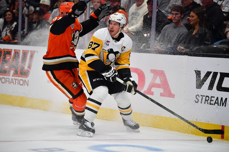 Oct 14, 2025; Anaheim, California, USA; Pittsburgh Penguins center Sidney Crosby (87) controls the puck against Anaheim Ducks defenseman Pavel Mintyukov (98) during the first period at Honda Center. Mandatory Credit: Gary A. Vasquez-Imagn Images