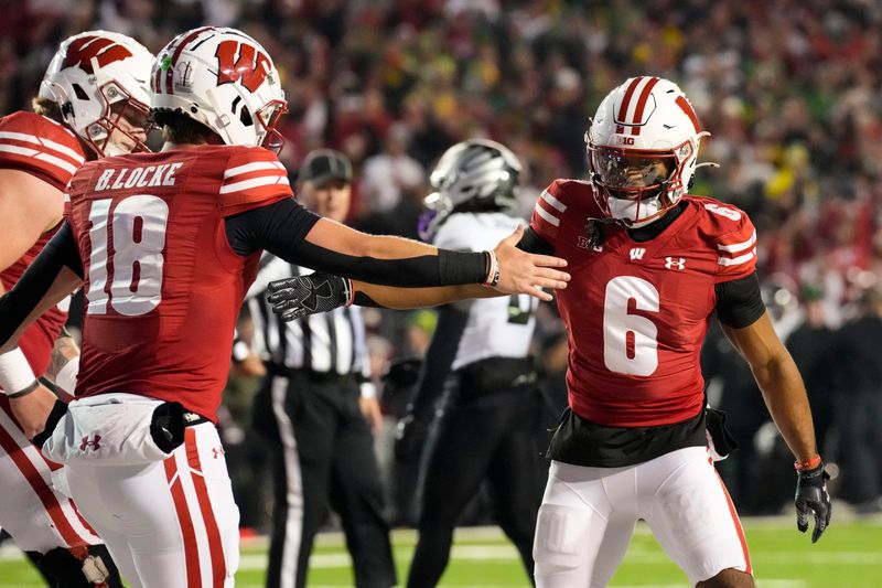 Nov 16, 2024; Madison, Wisconsin, USA;  Wisconsin Badgers wide receiver Will Pauling (6) celebrates with quarterback Braedyn Locke (18)  after scoring a touchdown during the second quarter against the Oregon Ducks at Camp Randall Stadium. Mandatory Credit: Jeff Hanisch-Imagn Images