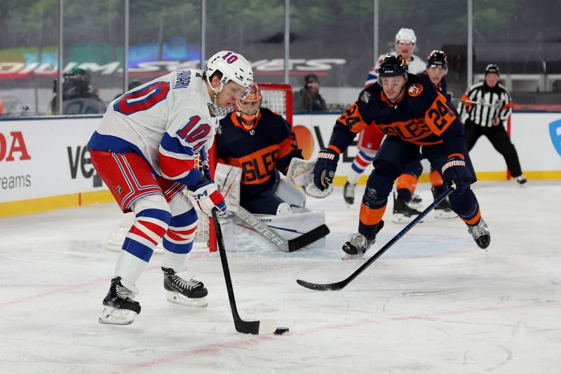 Feb 18, 2024; East Rutherford, New Jersey, USA; New York Rangers left wing Artemi Panarin (10) controls the puck against New York Islanders goaltender Ilya Sorokin (30) and defenseman Scott Mayfield (24) during the third period of a Stadium Series ice hockey game at MetLife Stadium. Mandatory Credit: Brad Penner-USA TODAY Sports