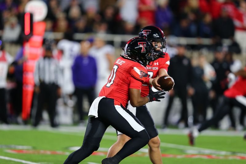 Nov 2, 2023; Lubbock, Texas, USA; Texas Tech Red Raiders quarterback Behren Morton (2) hands the ball to running back Cam   Rom Valdez (0) in the first half during the game against the Texas Christian Horned Frogs at Jones AT&T Stadium and Cody Campbell Field. Mandatory Credit: Michael C. Johnson-USA TODAY Sports