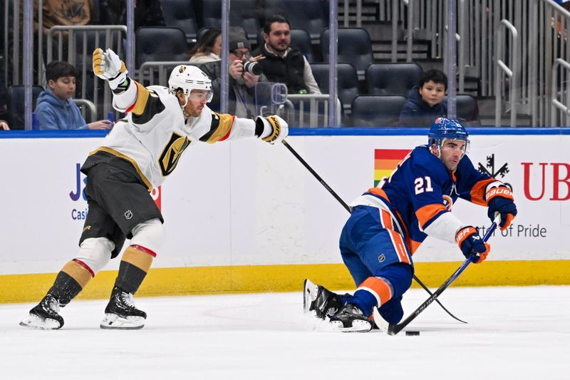 Jan 23, 2024; Elmont, New York, USA;  New York Islanders center Kyle Palmieri (21) plays it from his knees defended by Vegas Golden Knights right wing Mark Stone (61) during the third period at UBS Arena. Mandatory Credit: Dennis Schneidler-USA TODAY Sports