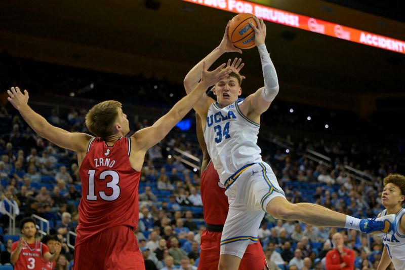 Feb 3, 2026; Los Angeles, California, USA;  UCLA Bruins forward Tyler Bilodeau (34) rebounds in front of Rutgers Scarlet Knights guard Harun Zrno (13) in the second half at Pauley Pavilion presented by Wescom Financial. Mandatory Credit: Jayne Kamin-Oncea-Imagn Images