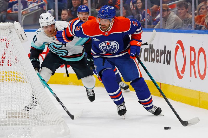 Sep 24, 2025; Edmonton, Alberta, CAN; Edmonton Oilers defensemen Evan Bouchard (2) moves the puck in front of Seattle Kraken forward Matty Beniers (10) during the second period at Rogers Place. Mandatory Credit: Perry Nelson-Imagn Images