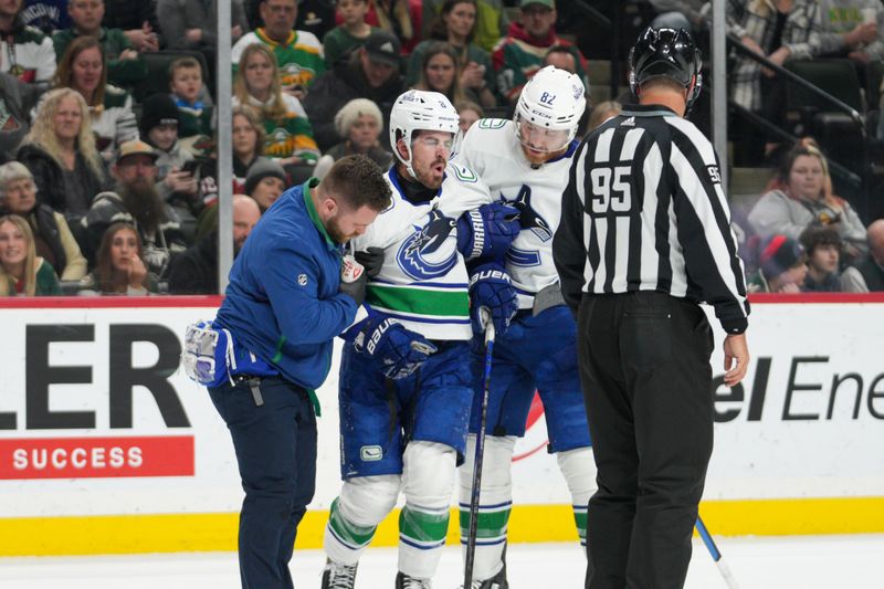 Feb 19, 2024; Saint Paul, Minnesota, USA; Vancouver Canucks right wing Conor Garland (8) is injured and helped off the ice by defenseman Ian Cole (82) and training staff in the second period as they played the Minnesota Wild at Xcel Energy Center. Mandatory Credit: Matt Blewett-USA TODAY Sports