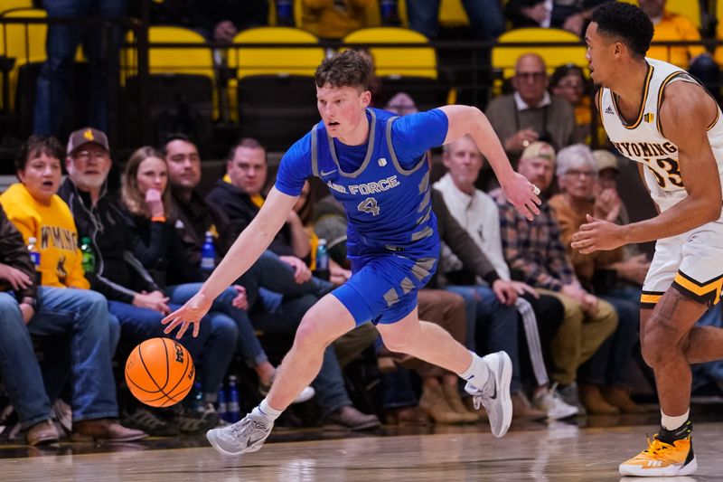 Feb 17, 2023; Laramie, Wyoming, USA; Air Force Falcons guard Carter Murphy (4) drives against Wyoming Cowboys guard Xavier DuSell (53) during the first half at Arena-Auditorium. Mandatory Credit: Troy Babbitt-USA TODAY Sports