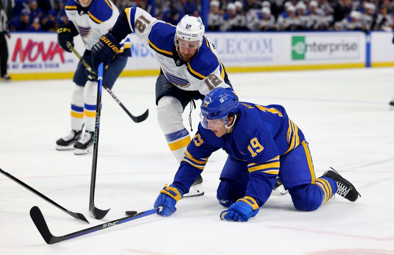 Feb 10, 2024; Buffalo, New York, USA;  St. Louis Blues right wing Kevin Hayes (12) goes after the puck as Buffalo Sabres center Peyton Krebs (19) falls during the second period at KeyBank Center. Mandatory Credit: Timothy T. Ludwig-USA TODAY Sports