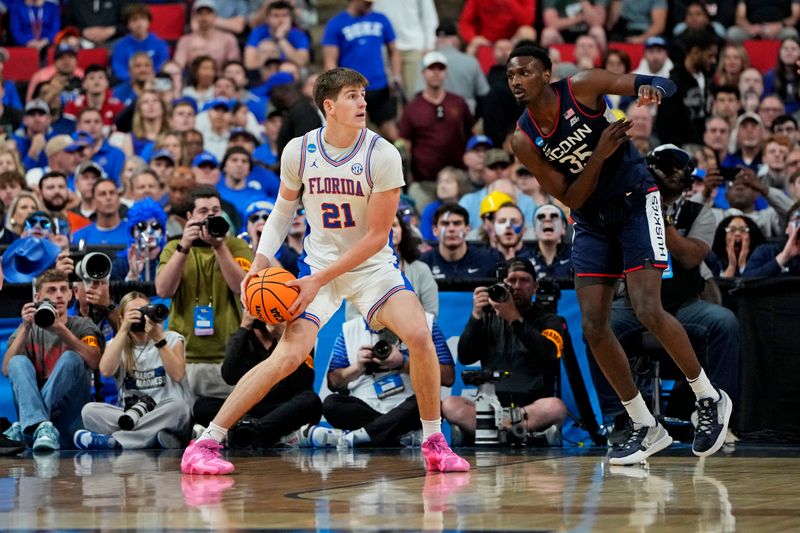 Mar 23, 2025; Raleigh, NC, USA; Florida Gators forward Alex Condon (21) drives to the basket as Connecticut Huskies center Samson Johnson (35) defends during the first half in the second round of the NCAA Tournament at Lenovo Center. Mandatory Credit: Bob Donnan-Imagn Images