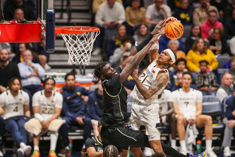 Feb 20, 2024; Morgantown, West Virginia, USA; West Virginia Mountaineers guard RaeQuan Battle (21) shoots against UCF Knights forward Ibrahima Diallo (11) during the second half at WVU Coliseum. Mandatory Credit: Ben Queen-USA TODAY Sports