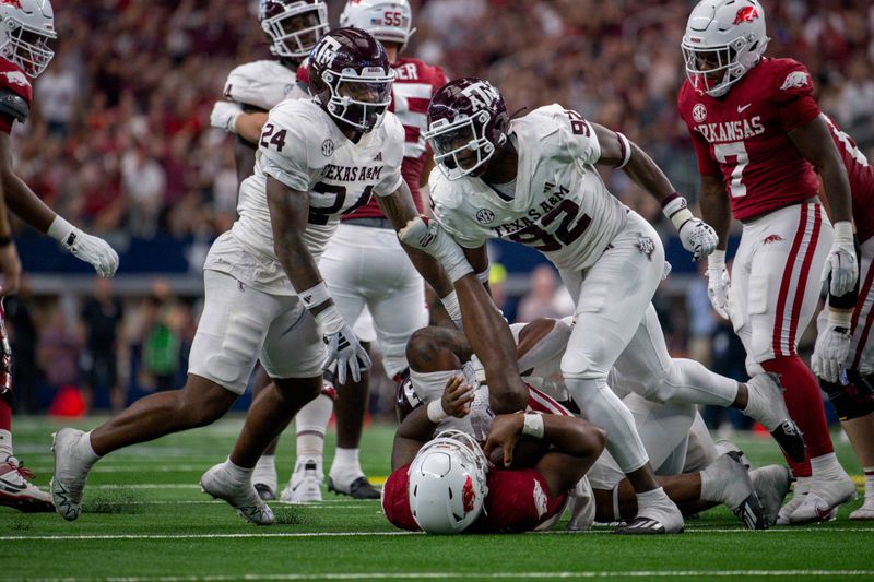 Sep 30, 2023; Arlington, Texas, USA; Texas A&M Aggies linebacker Chris Russell Jr. (24) and defensive lineman Malick Sylla (92) celebrate a sack of Arkansas Razorbacks quarterback KJ Jefferson (1) during the second half at AT&T Stadium. Mandatory Credit: Jerome Miron-USA TODAY Sports