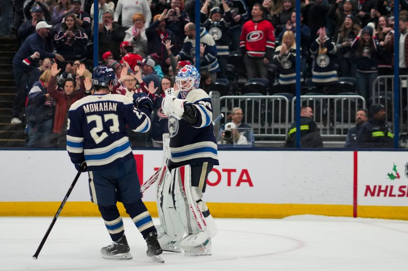 Nov 23, 2024; Columbus, Ohio, USA;  Columbus Blue Jackets goaltender Elvis Merzlikins (90) and center Sean Monahan (23) celebrate after defeating the Carolina Hurricanes in a shootout at Nationwide Arena. Mandatory Credit: Aaron Doster-Imagn Images