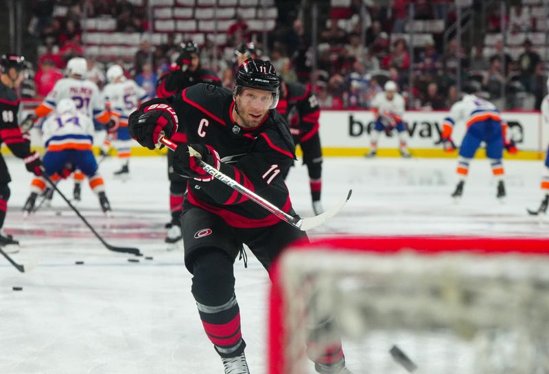 Apr 20, 2024; Raleigh, North Carolina, USA; Carolina Hurricanes center Jordan Staal (11) takes a shot during the warmups before the game against the New York Islanders in game one of the first round of the 2024 Stanley Cup Playoffs at PNC Arena. Mandatory Credit: James Guillory-USA TODAY Sports