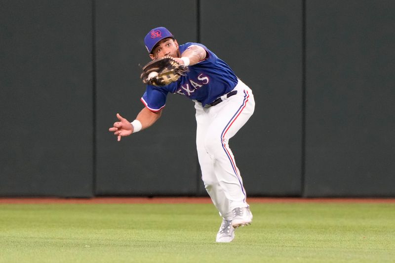 Mar 28, 2023; Arlington, Texas, USA; Texas Rangers left fielder Ezequiel Duran (20) catches the fly-out hit by Kansas City Royals left fielder Kyle Isbel (28) during the fifth inning of an exhibition game at Globe Life Field. Mandatory Credit: Jim Cowsert-USA TODAY Sports