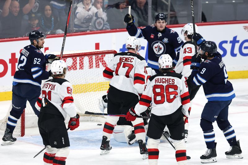 Jan 11, 2026; Winnipeg, Manitoba, CAN; Winnipeg Jets left wing Alex Iafallo (9) celebrates a goal on New Jersey Devils goaltender Jake Allen (34) in the first period at Canada Life Centre. Mandatory Credit: James Carey Lauder-Imagn Images