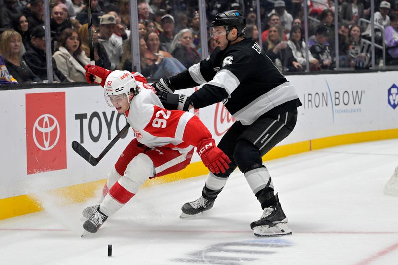 Nov 16, 2024; Los Angeles, California, USA; Detroit Red Wings center Marco Kasper (92) and Los Angeles Kings defenseman Joel Edmundson (6) battle for the puck in the third period at Crypto.com Arena. Mandatory Credit: Jayne Kamin-Oncea-Imagn Images