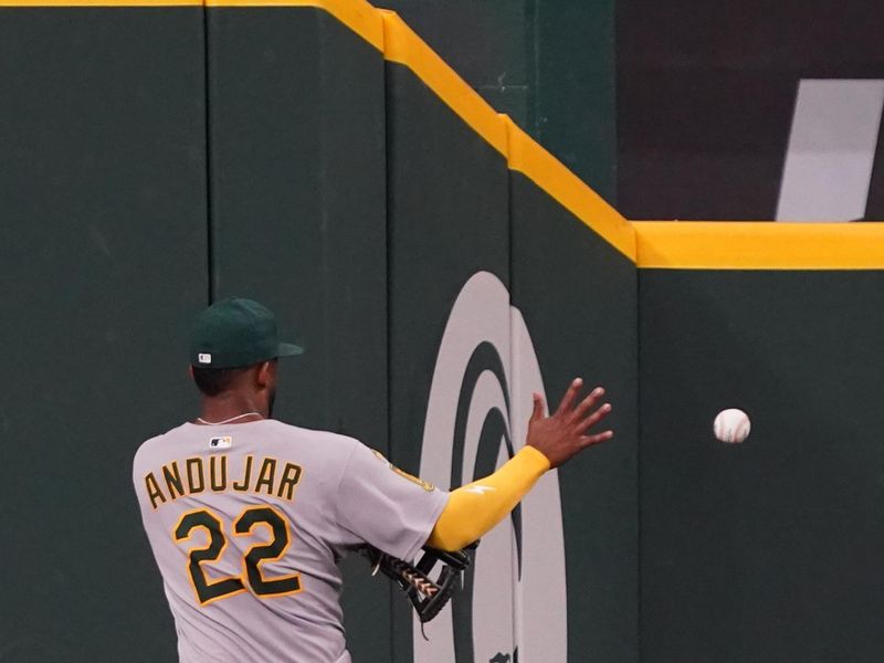 Apr 28, 2025; Arlington, Texas, USA; Athletics outfielder Miguel Andujar (22) plays the carom off the outfield wall against the Texas Rangers during the sixth inning at Globe Life Field. Mandatory Credit: Raymond Carlin III-Imagn Images