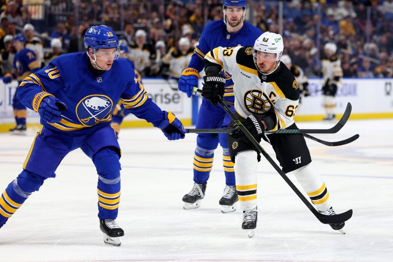 Jan 28, 2025; Buffalo, New York, USA;  Buffalo Sabres defenseman Henri Jokiharju (10) and Boston Bruins left wing Brad Marchand (63) go after a loose puck during the third period at KeyBank Center. Mandatory Credit: Timothy T. Ludwig-Imagn Images