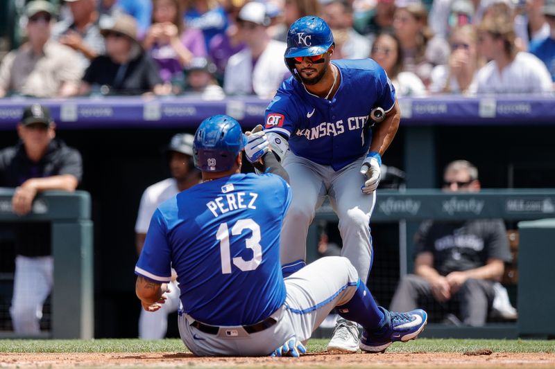 Jul 7, 2024; Denver, Colorado, USA; Kansas City Royals left fielder MJ Melendez (1) helps first baseman Salvador Perez (13) up after he scored on an RBI in the second inning against the Colorado Rockies at Coors Field. Mandatory Credit: Isaiah J. Downing-USA TODAY Sports