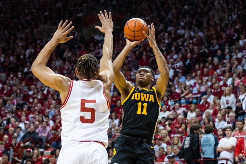 Feb 28, 2023; Bloomington, Indiana, USA; Iowa Hawkeyes guard Tony Perkins (11) shoots the ball while Indiana Hoosiers forward Malik Reneau (5) defends in the second half at Simon Skjodt Assembly Hall. Mandatory Credit: Trevor Ruszkowski-USA TODAY Sports