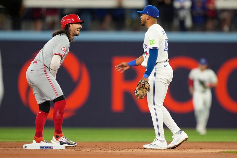 Aug 20, 2024; Toronto, Ontario, CAN; Cincinnati Reds designated hitter Jonathan India (6) laughs with Toronto Blue Jays shortstop Leo Jimenez (49) after being tagged out running to second base during the first inning at Rogers Centre. Mandatory Credit: John E. Sokolowski-USA TODAY Sports