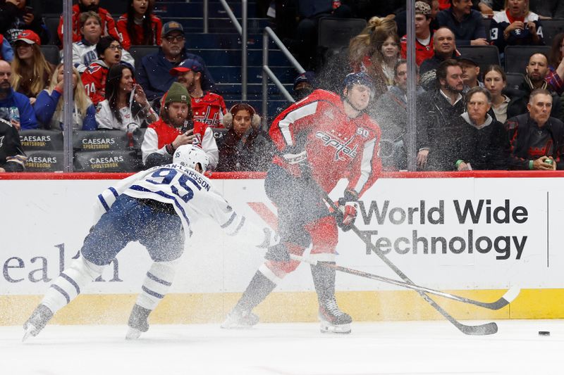 Nov 13, 2024; Washington, District of Columbia, USA; Washington Capitals center Aliaksei Protas (21) passes the puck as Toronto Maple Leafs defenseman Oliver Ekman-Larsson (95) defends in the third period at Capital One Arena. Mandatory Credit: Geoff Burke-Imagn Images