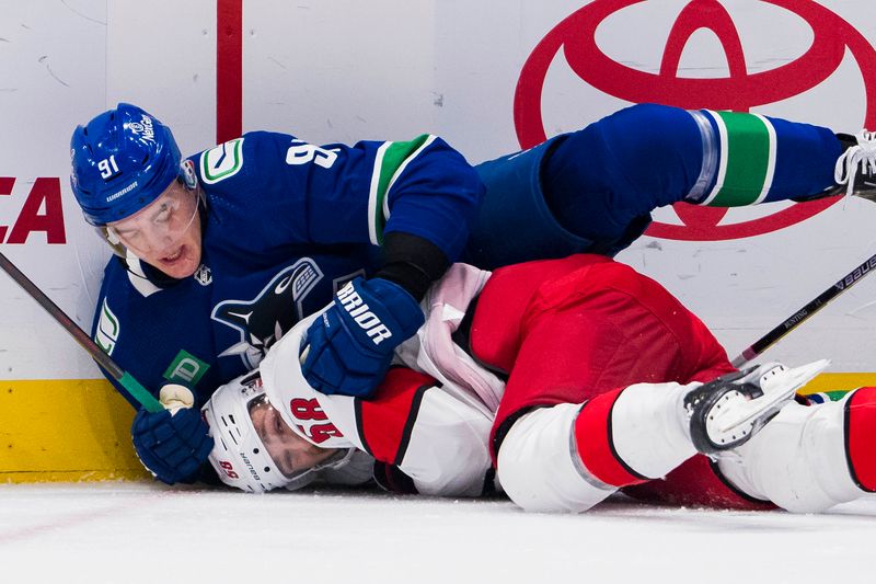 Dec 9, 2023; Vancouver, British Columbia, CAN; Vancouver Canucks defenseman Nikita Zadorov (91) tackles Carolina Hurricanes forward Michael Bunting (58) in the second period at Rogers Arena. Mandatory Credit: Bob Frid-USA TODAY Sports