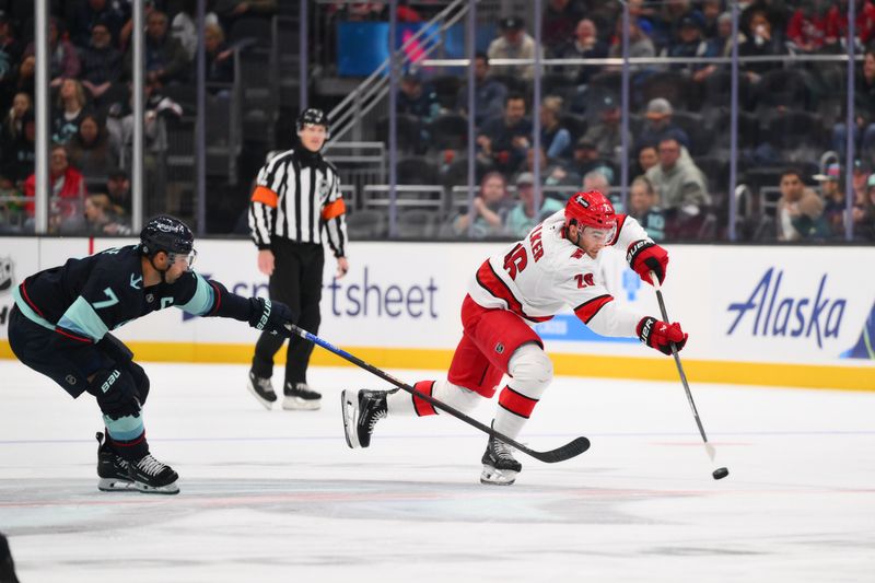 Oct 26, 2024; Seattle, Washington, USA; Carolina Hurricanes defenseman Sean Walker (26) passes the puck while defended by Seattle Kraken right wing Jordan Eberle (7) during the second period at Climate Pledge Arena. Mandatory Credit: Steven Bisig-Imagn Images