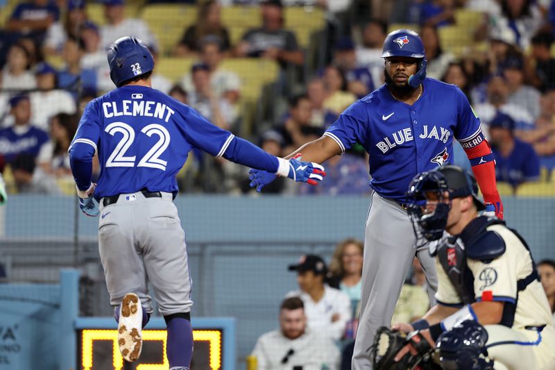Aug 9, 2025; Los Angeles, California, USA;  Toronto Blue Jays third baseman Ernie Clement (22) is greeted by designated hitter Vladimir Guerrero Jr. (27, right) after hitting a home run during the eighth inning against the Los Angeles Dodgers at Dodger Stadium. Mandatory Credit: Kiyoshi Mio-Imagn Images