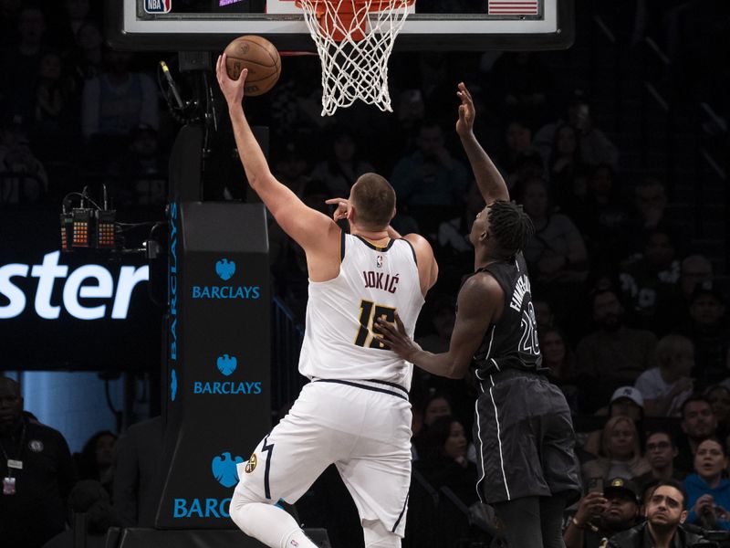 NEW YORK, NEW YORK - OCTOBER 29: Nikola Jokic #15 of the Denver Nuggets makes a shot over Dorian Finney-Smith #28 of the Brooklyn Nets during the first half at Barclays Center on October 29, 2024 in New York City. NOTE TO USER: User expressly acknowledges and agrees that, by downloading and or using this Photograph, user is consenting to the terms and conditions of the Getty Images License Agreement. (Photo by Michelle Farsi/Getty Images)