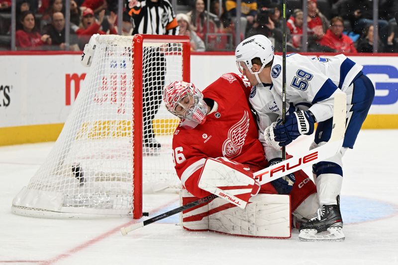 Nov 28, 2025; Detroit, Michigan, USA; Tampa Bay Lightning center Jake Guentzel (59) crashes into Detroit Red Wings goaltender John Gibson (36) after scoring a goal in the third period at Little Caesars Arena. Mandatory Credit: Lon Horwedel-Imagn Images