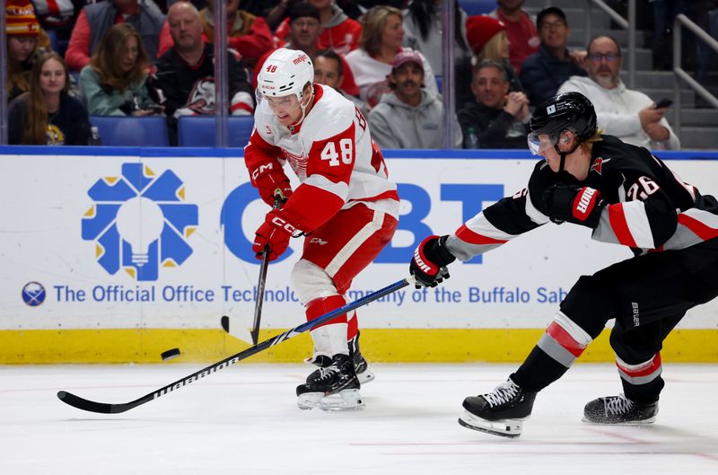 Oct 26, 2024; Buffalo, New York, USA;  Buffalo Sabres defenseman Rasmus Dahlin (26) tries to block a pass by Detroit Red Wings right wing Jonatan Berggren (48) during the third period at KeyBank Center. Mandatory Credit: Timothy T. Ludwig-Imagn Images