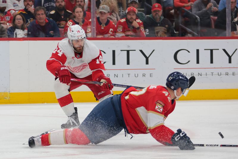 Apr 10, 2025; Sunrise, Florida, USA; Detroit Red Wings center Tyler Motte (14) moves the puck as Florida Panthers defenseman Gustav Forsling (42) defends during the second period at Amerant Bank Arena. Mandatory Credit: Sam Navarro-Imagn Images