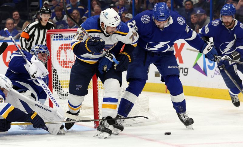 Dec 19, 2023; Tampa, Florida, USA; Tampa Bay Lightning left wing Nicholas Paul (20) and St. Louis Blues defenseman Justin Faulk (72) fight to control the puck  during the second period at Amalie Arena. Mandatory Credit: Kim Klement Neitzel-USA TODAY Sports