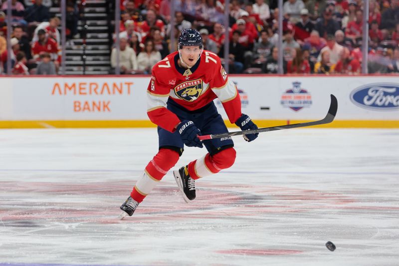 Nov 28, 2025; Sunrise, Florida, USA; Florida Panthers defenseman Niko Mikkola (77) moves the puck against the Calgary Flames during the first period at Amerant Bank Arena. Mandatory Credit: Sam Navarro-Imagn Images
