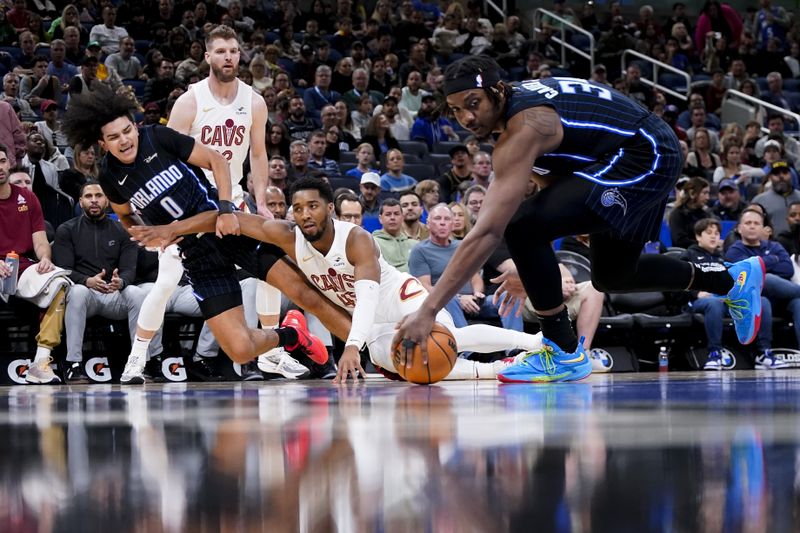 ORLANDO, FLORIDA - JANUARY 22: Anthony Black #0 of the Orlando Magic and Donovan Mitchell #45 of the Cleveland Cavaliers go to the floor for a loose ball during the first quarter at Kia Center on January 22, 2024 in Orlando, Florida. NOTE TO USER: User expressly acknowledges and agrees that, by downloading and or using this photograph, User is consenting to the terms and conditions of the Getty Images License Agreement. (Photo by Rich Storry/Getty Images)