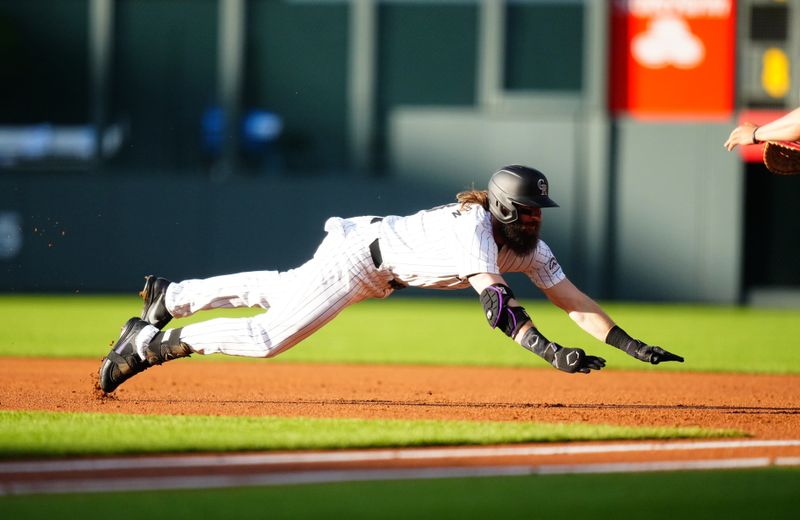 May 28, 2024; Denver, Colorado, USA; Colorado Rockies outfielder Charlie Blackmon (19) dives back to first after his single in the first inning against the Cleveland Guardians at Coors Field. Mandatory Credit: Ron Chenoy-USA TODAY Sports