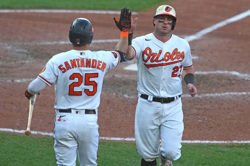 Oct 1, 2023; Baltimore, Maryland, USA; Baltimore Orioles catcher James McCann (27) is greeted by outfielder Anthony Santander (25) after scoring a run in the eighth inning against the Boston Red Sox at Oriole Park at Camden Yards. Mandatory Credit: Mitch Stringer-USA TODAY Sports