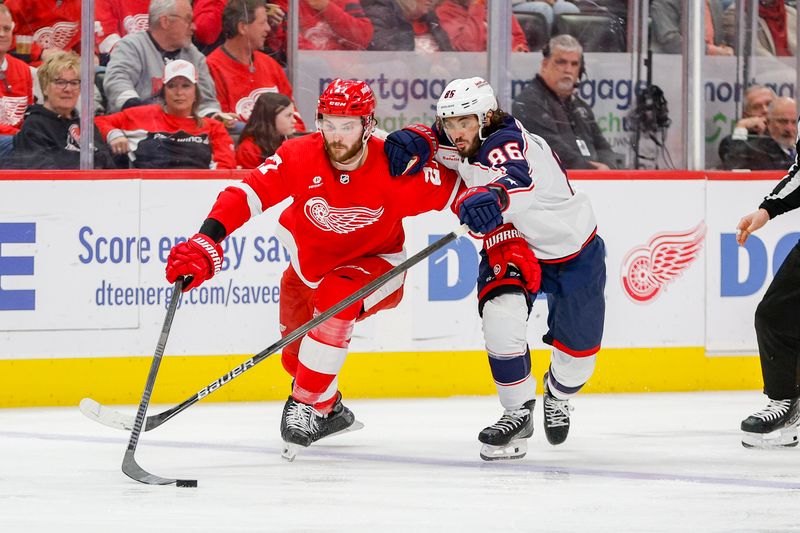 Mar 19, 2024; Detroit, Michigan, USA; Detroit Red Wings center Michael Rasmussen (27) fights for control of the puck with Columbus Blue Jackets right wing Kirill Marchenko (86) during the third period of the game at Little Caesars Arena. Mandatory Credit: Brian Bradshaw Sevald-USA TODAY Sports