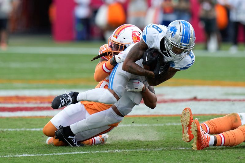 Detroit Lions wide receiver Josh Reynolds (8) is tackled by Tampa Bay Buccaneers safety Ryan Neal (23) during the first half of an NFL football game Sunday, Oct. 15, 2023, in Tampa, Fla. (AP Photo/Chris O'Meara)