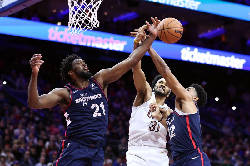 PHILADELPHIA, PENNSYLVANIA - NOVEMBER 21: Jarrett Allen #31 of the Cleveland Cavaliers reaches for a rebound between Joel Embiid #21 and Tobias Harris #12 of the Philadelphia 76ers during overtime at the Wells Fargo Center on November 21, 2023 in Philadelphia, Pennsylvania. NOTE TO USER: User expressly acknowledges and agrees that, by downloading and or using this photograph, User is consenting to the terms and conditions of the Getty Images License Agreement. (Photo by Tim Nwachukwu/Getty Images)