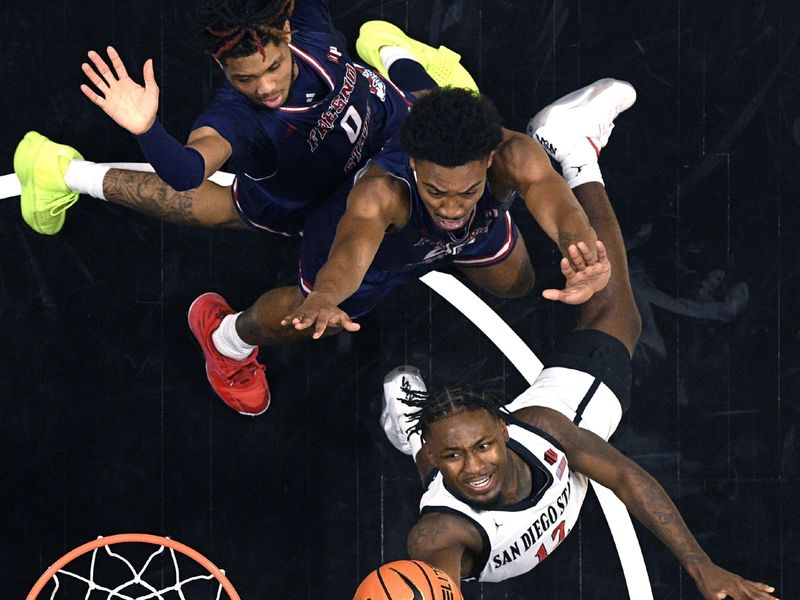 Jan 3, 2024; San Diego, California, USA; San Diego State Aztecs guard Darrion Trammell (12) goes to the basket past Fresno State Bulldogs guard Leo Colimerio (23) and guard Donavan Yap Jr. (0) during the first half at Viejas Arena. Mandatory Credit: Orlando Ramirez-USA TODAY Sports 